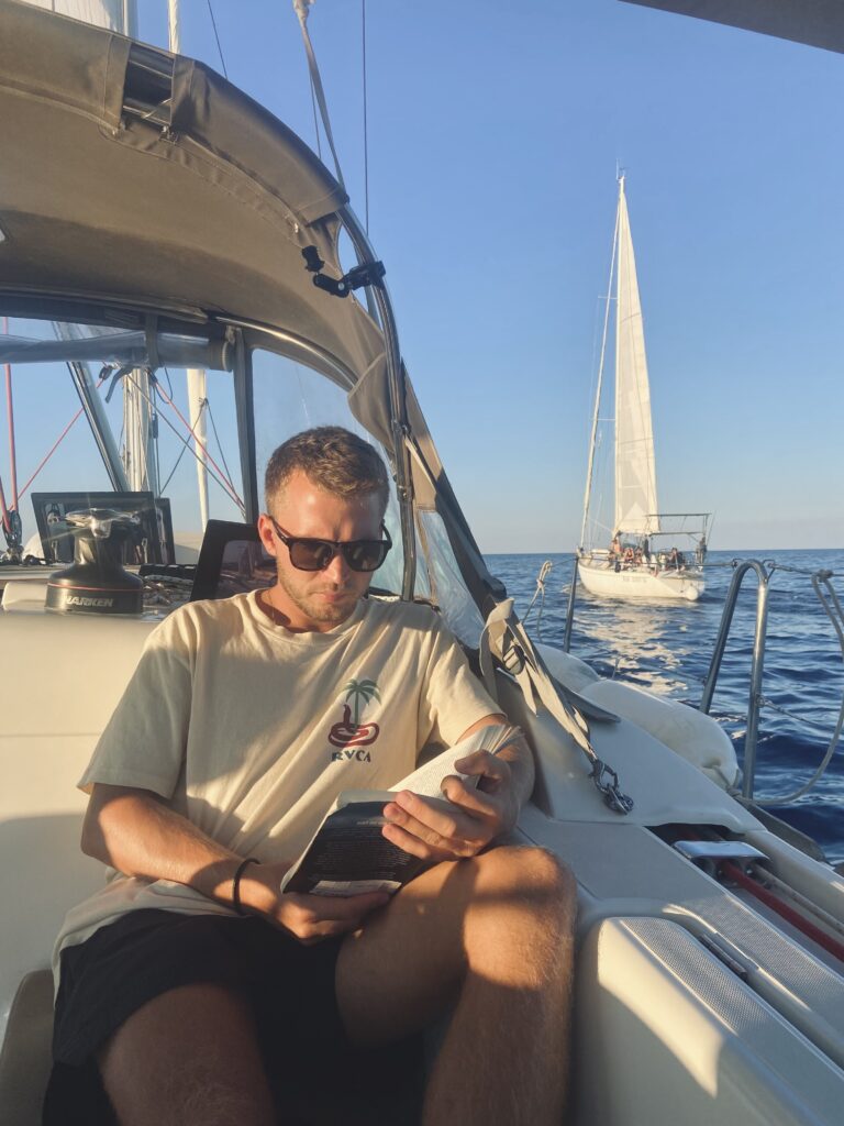 Stefan reading on sailing boat
