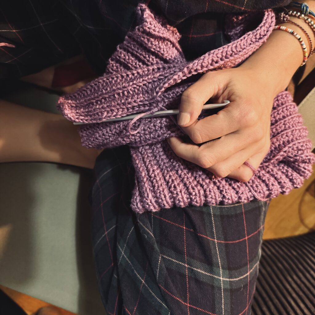 Erica handmaking a VAGOBEANIE in its lila variation "ALESSIA"
